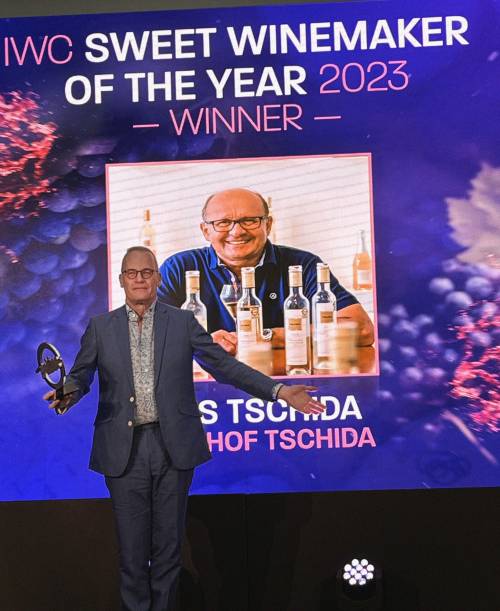 Tim Atkin MW on stage in front of the projection of the Sweet Winemakers of the Year Hans Tschida.