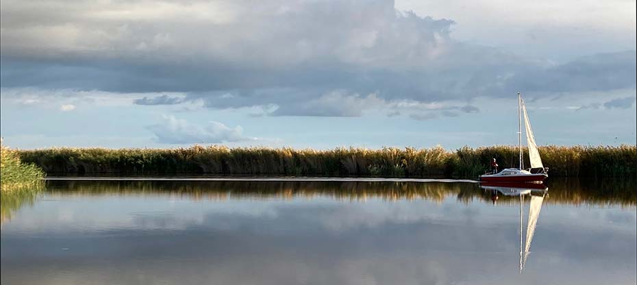 A sailing boat reflected in the autumnal Neusiedlersee
